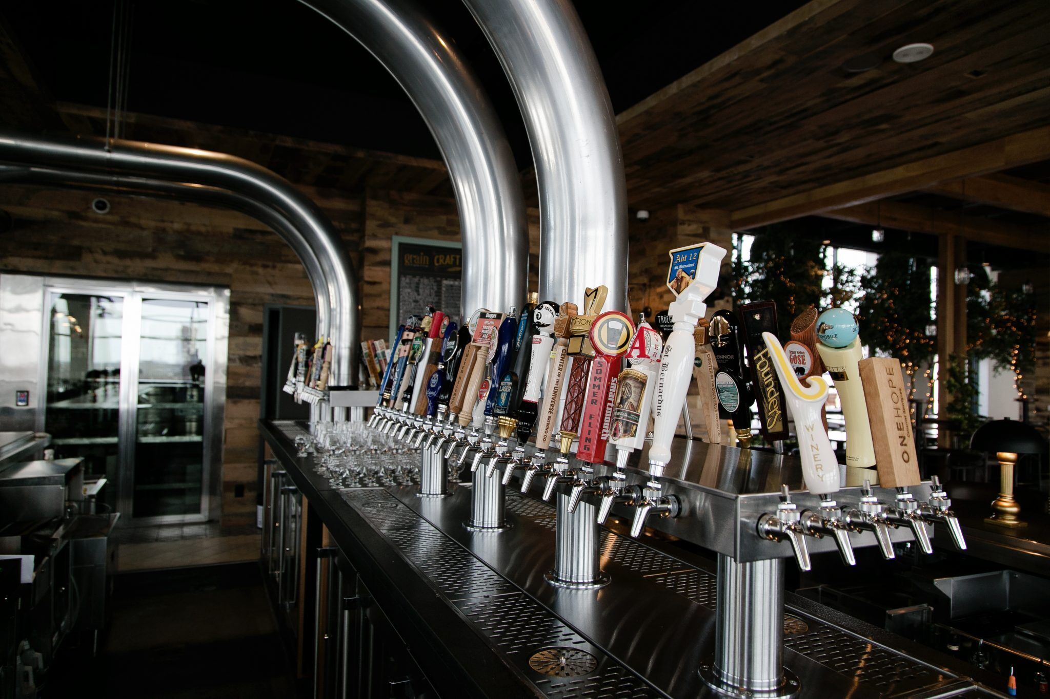 A bar with multiple taps and a variety of beer bottles.