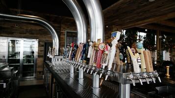 A bar with multiple taps and a variety of beer bottles.