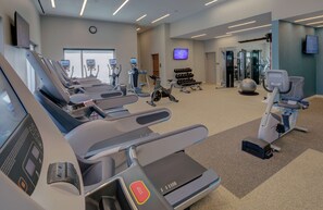 A modern gym with treadmills, stationary bikes, and weight machines. - Hilton Norfolk The Main (Norfolk)