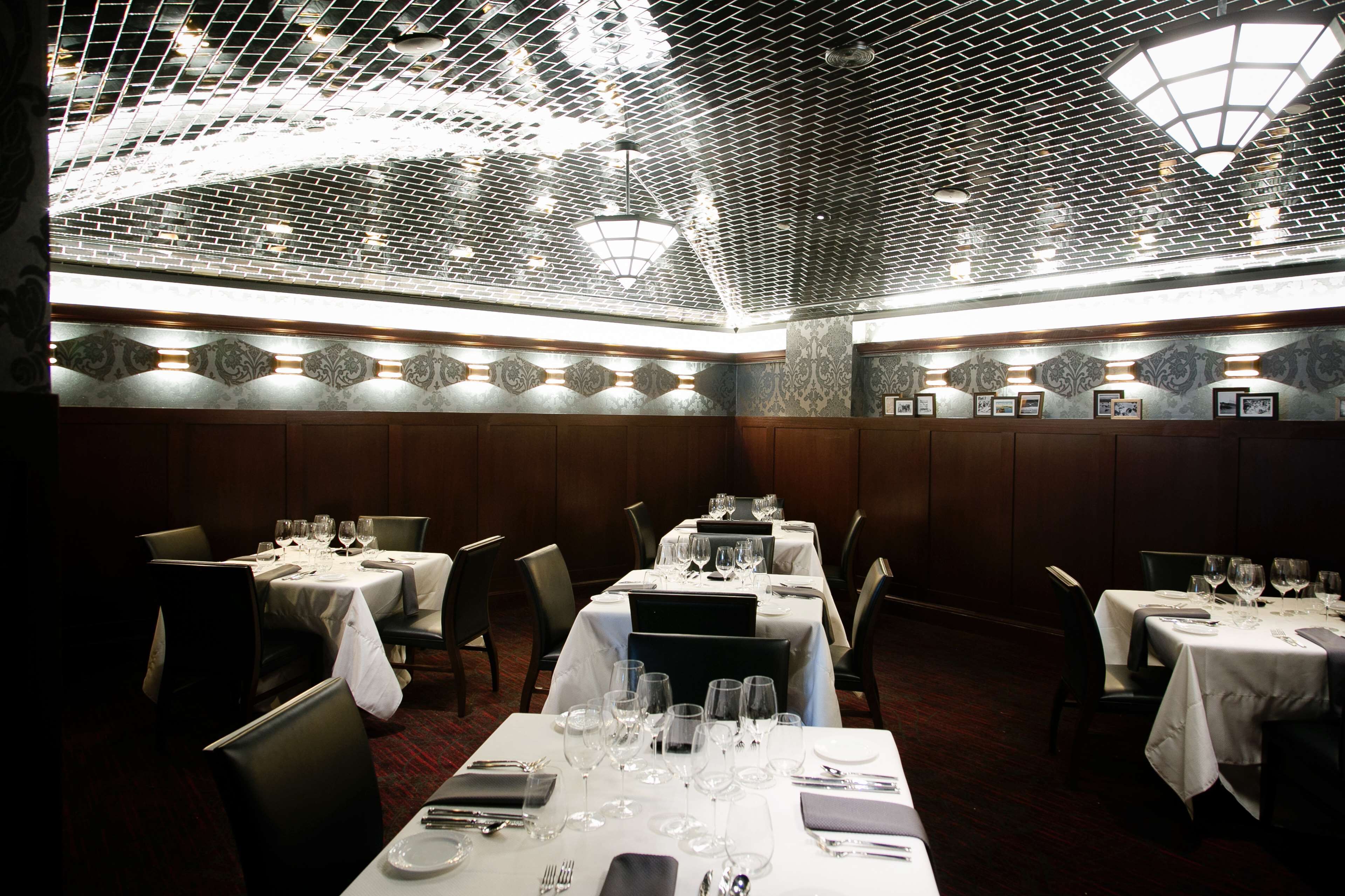 Ein Restaurant mit gedeckten Tischen, verziertem Deckenmuster und Wandgestaltung.