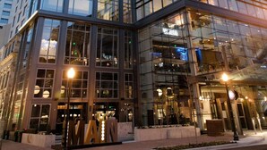A modern hotel with a glass facade, a prominent 'Hilton' sign, and a 'Manhattan' sign indicating its location. - Hilton Norfolk The Main (Norfolk)