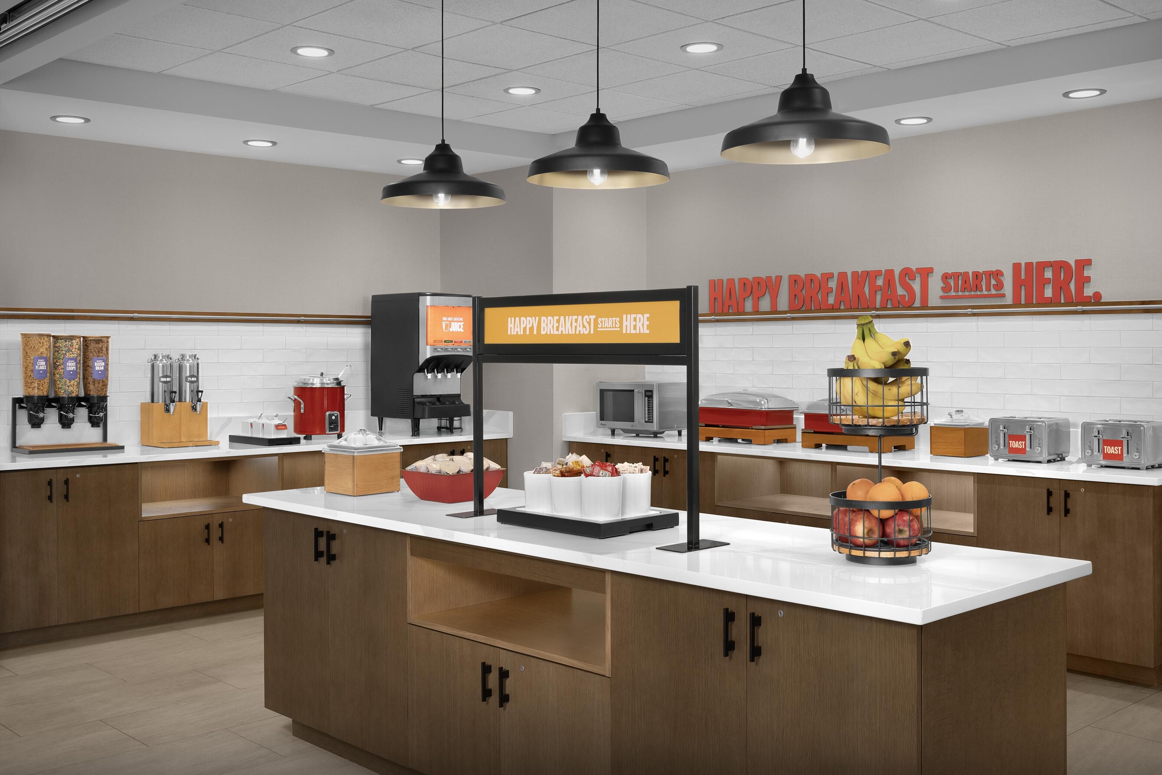 Una barra de desayuno con un cartel que dice 'HAPPY BREAKFAST STARTS HERE'.