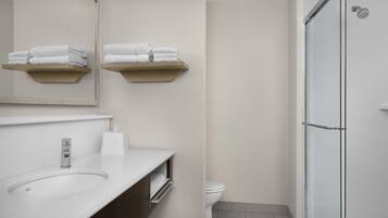 A modern bathroom with a sink, toilet, and shower.