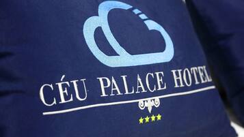 Een kussen met de tekst 'Céu Palace Hotel' en een logo.