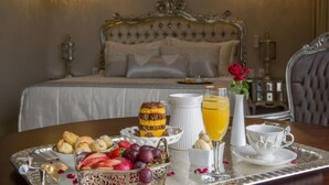 A breakfast tray with pastries, fruits, and a glass of orange juice on a table in a hotel room. - Céu Palmas Hotel (Palmas)