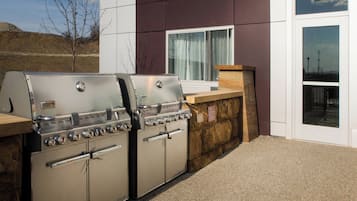A barbecue grill set against a building exterior.
