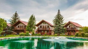 A row of chalet-style buildings with a central pond and a fountain.