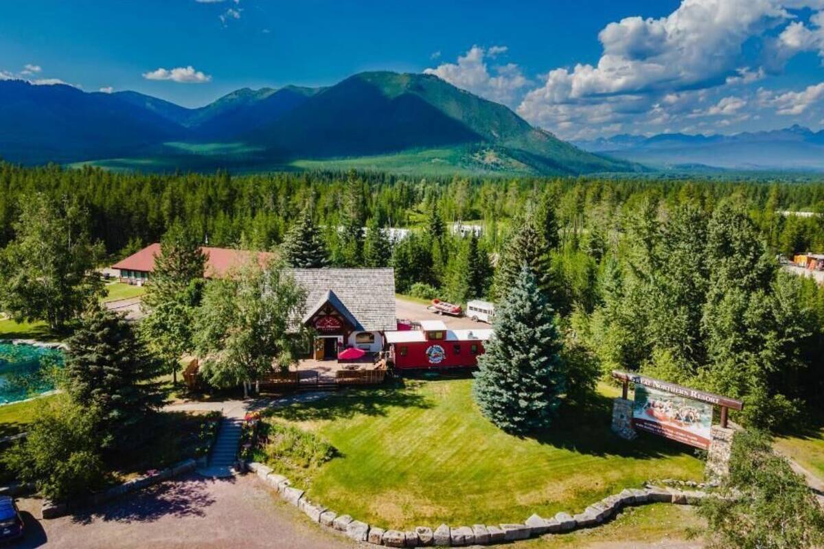 A lodge surrounded by dense forest and mountains.