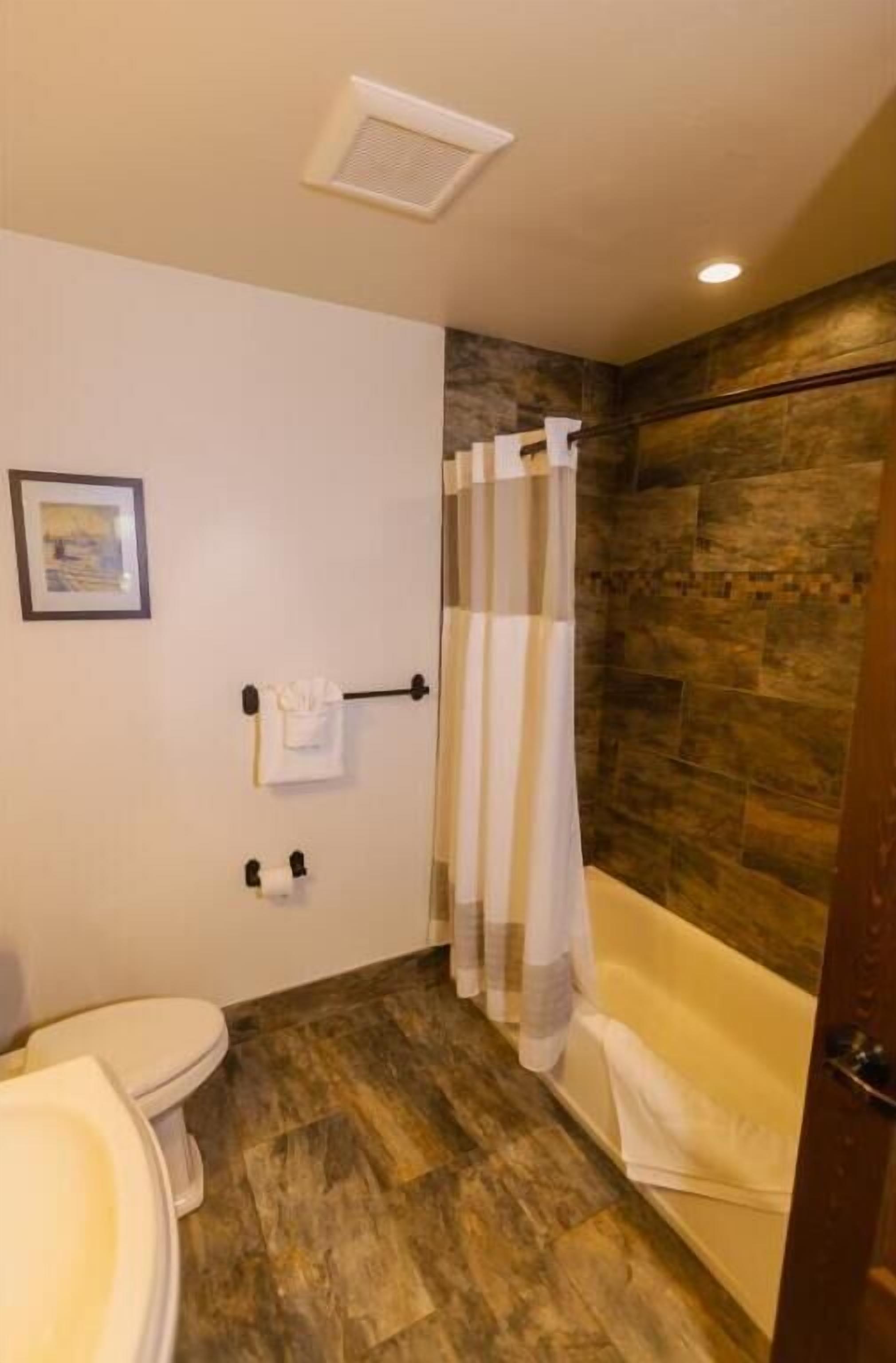 Kombinert dusj/badekar, toalettartikler (inkludert) og hårføner