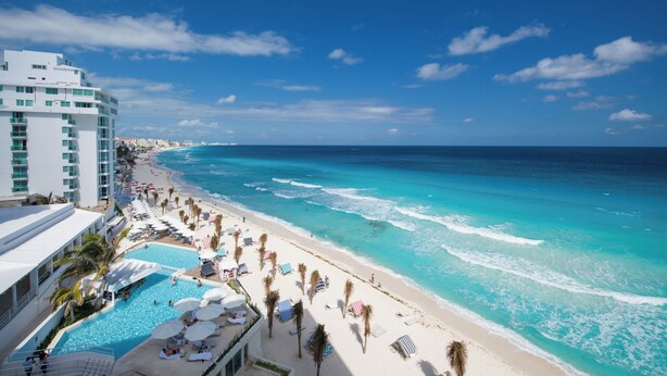 Un resort con piscina, playa y vista al océano.