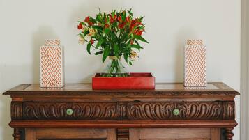 Eine Holzkommode mit einer Blumenvase und zwei verzierten Kisten darauf.