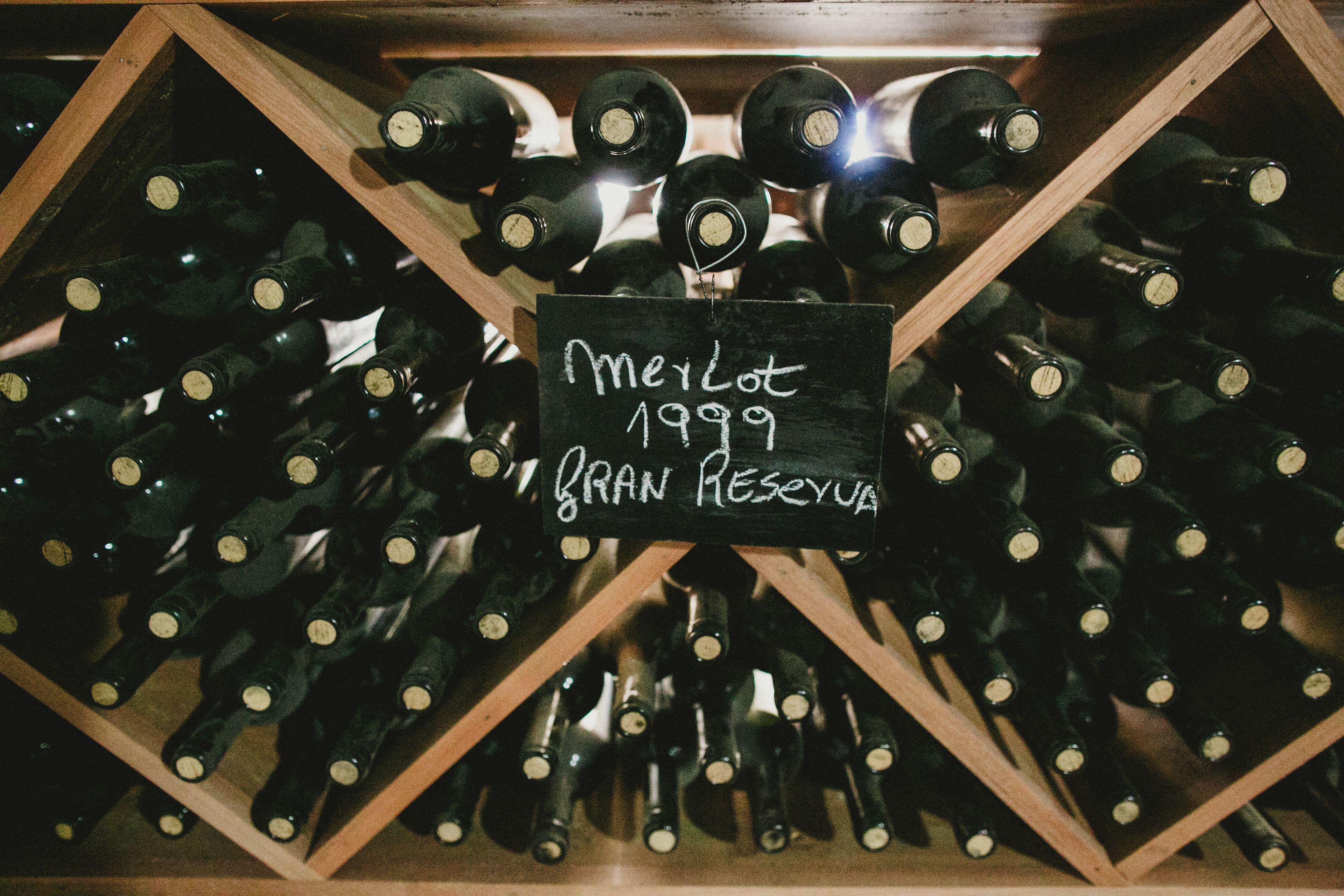Una botellera con botellas etiquetadas 'Merlot 1999 Gran Reserva'.