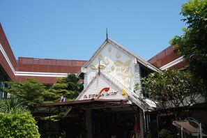 A building with a distinctive roof design and a sign with Thai script.