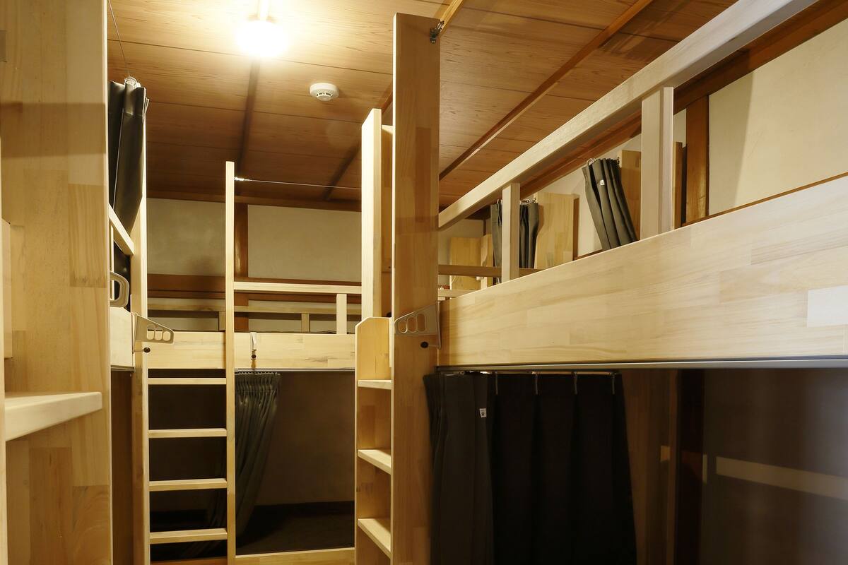 A bunk bed room with wooden floors and shelves.
