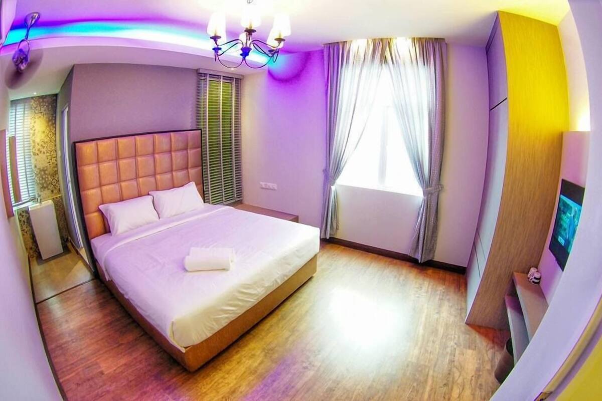 Une chambre d’hôtel moderne avec un grand lit, un téléviseur à écran plat et un plancher en bois.