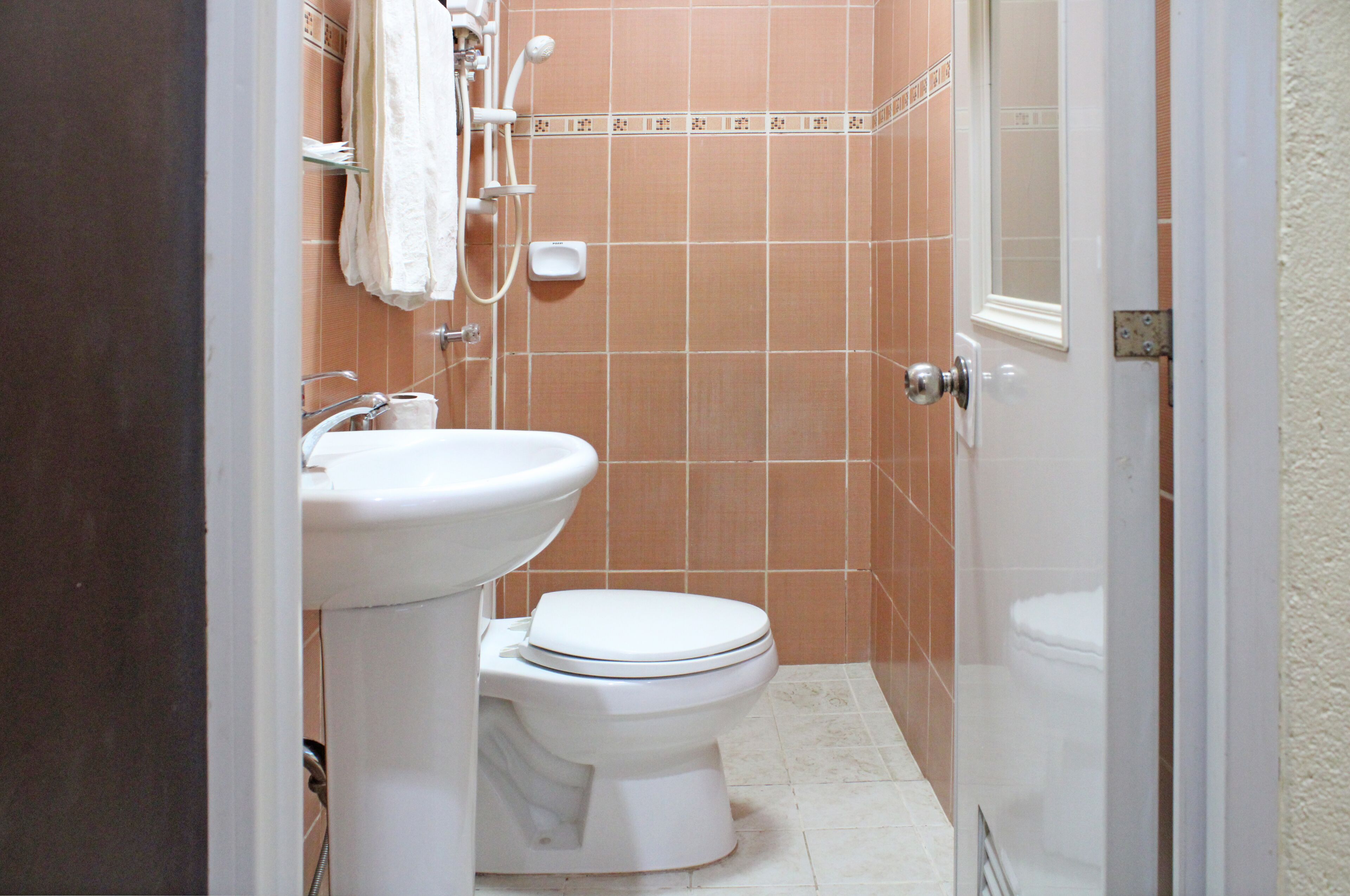 Un baño pequeño y limpio con inodoro, lavabo y ducha.