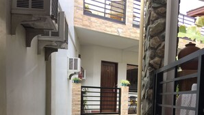 A multi-level courtyard with a staircase, potted plants, and a stone wall. - Balaibinda Lodge (Coron)