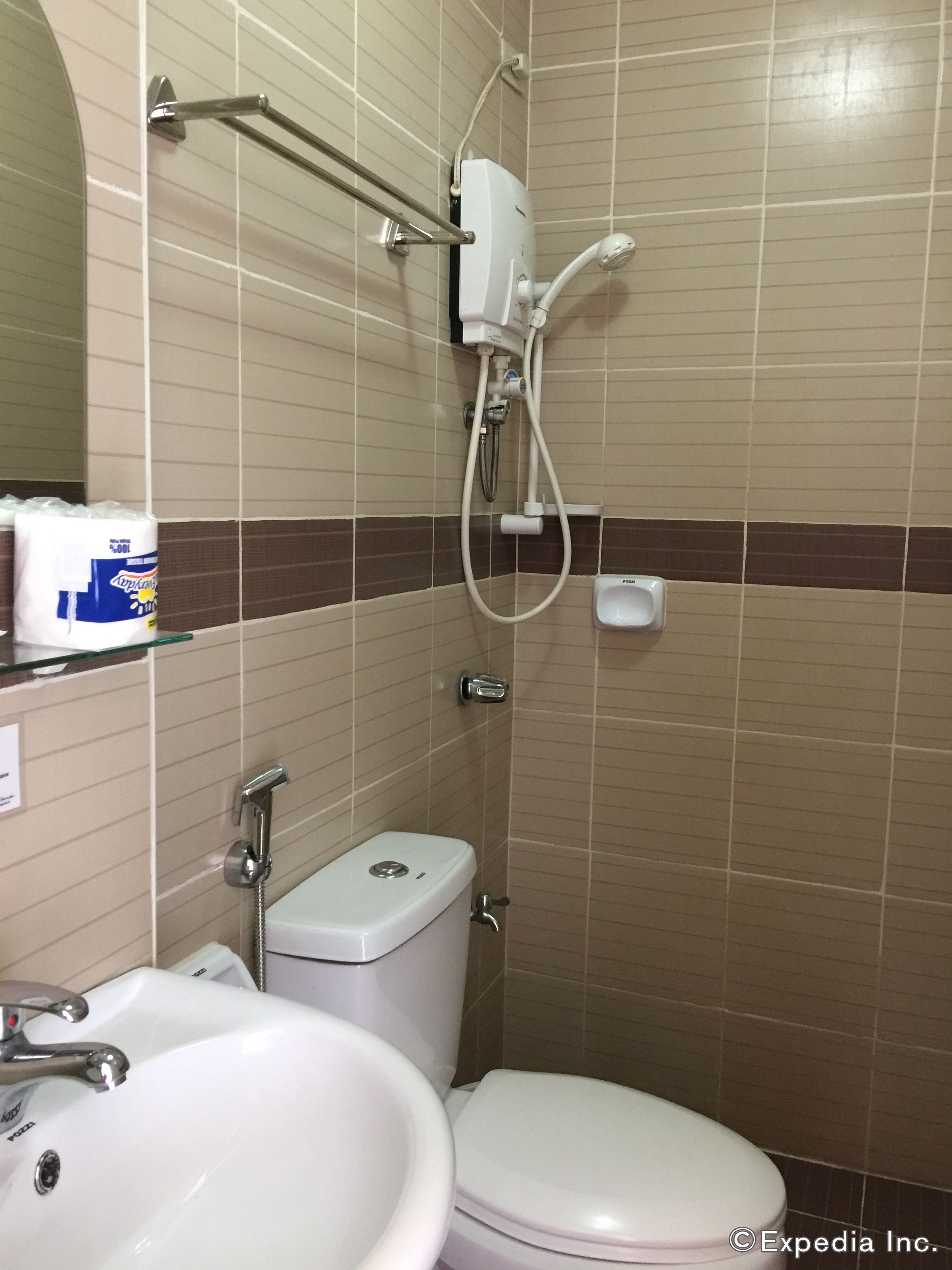 A bathroom with a toilet, sink, and shower.