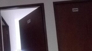 A hallway with two doors, one labeled 203 and the other 204, leading to rooms. - Hotel Zafiro Real (Anapoima)