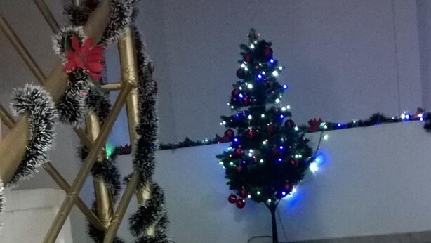 A staircase with a decorative garland and a Christmas tree with lights. - Hotel Zafiro Real (Anapoima)