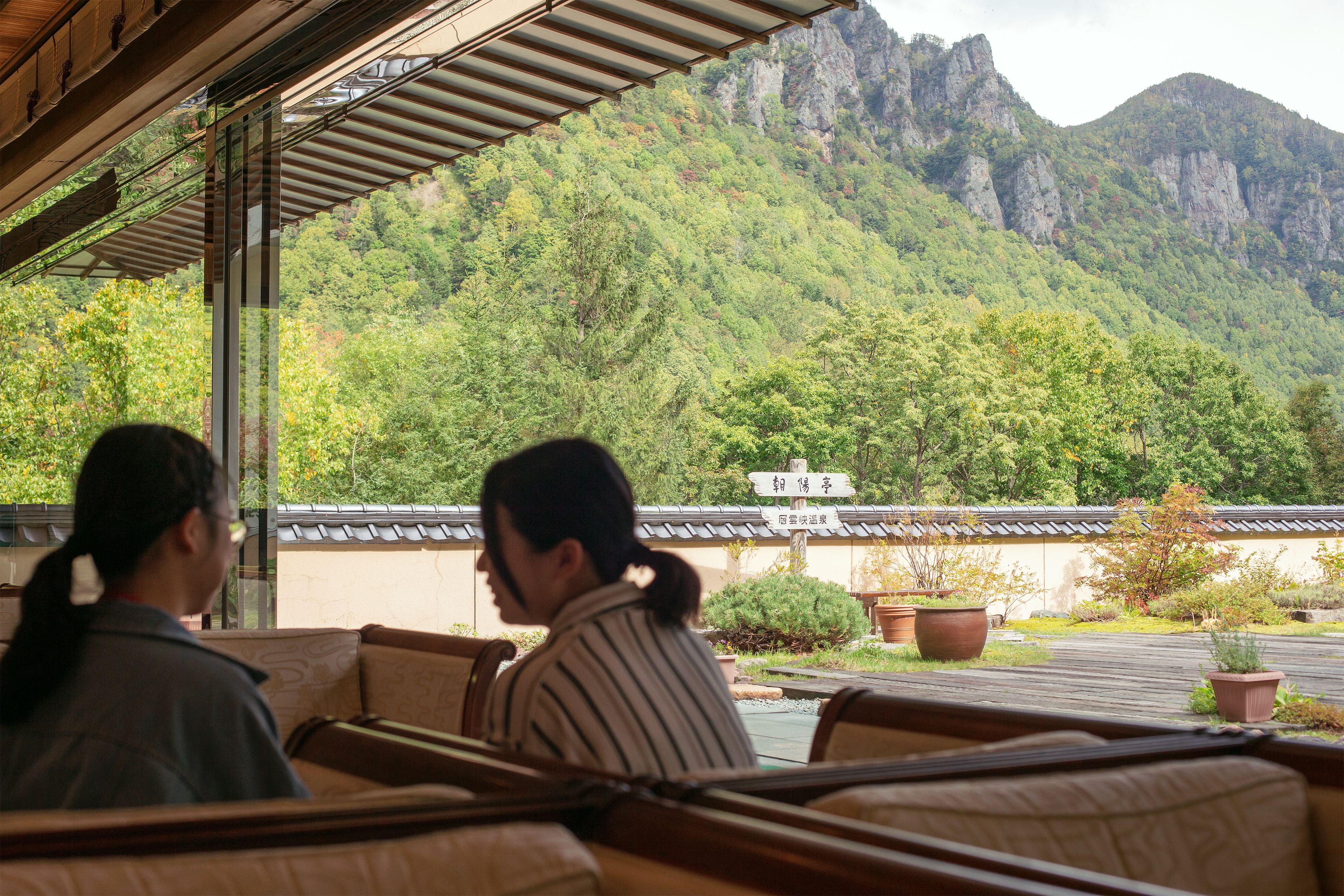 A restaurant with a view of mountains and a traditional building in the background.