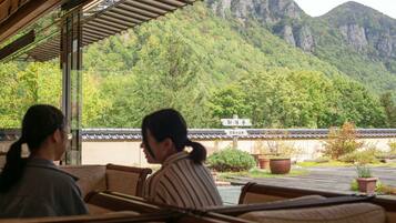 A restaurant with a view of mountains and a traditional building in the background.