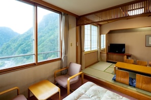 Experience a serene retreat with a traditional Japanese aesthetic, featuring tatami flooring and shoji screens, and a comfortable seating area with a sofa and chairs.