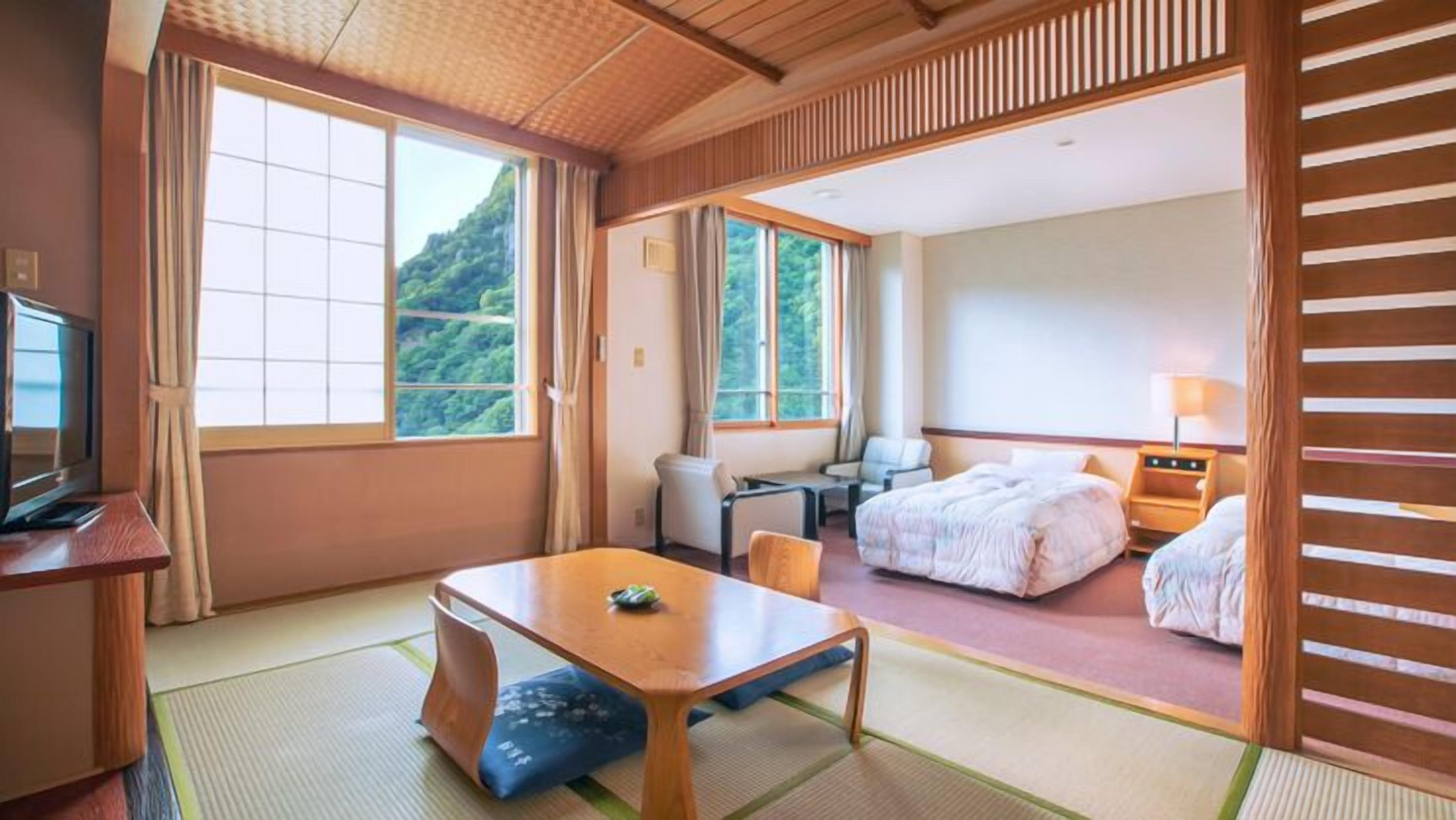 Een hotelkamer met een bed, bureau, stoel en televisie.