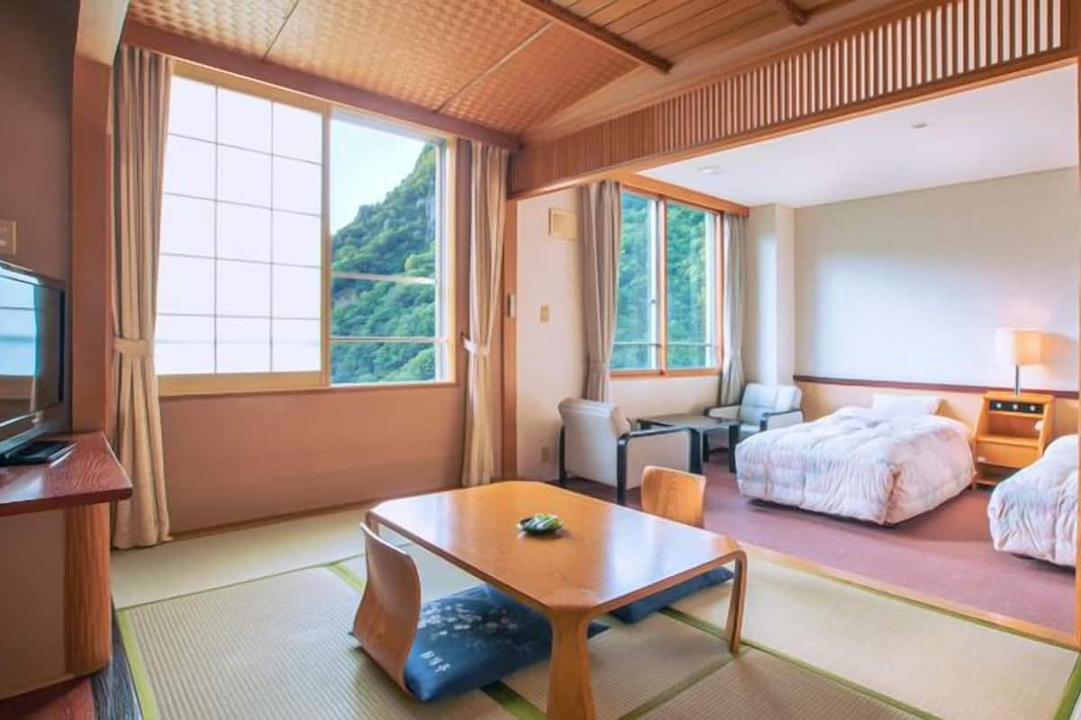 Une chambre d’hôtel avec un lit, un bureau, une chaise et un téléviseur.