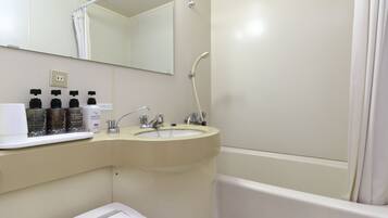 A bathroom with a sink, mirror, shower, and a shelf with toiletries.