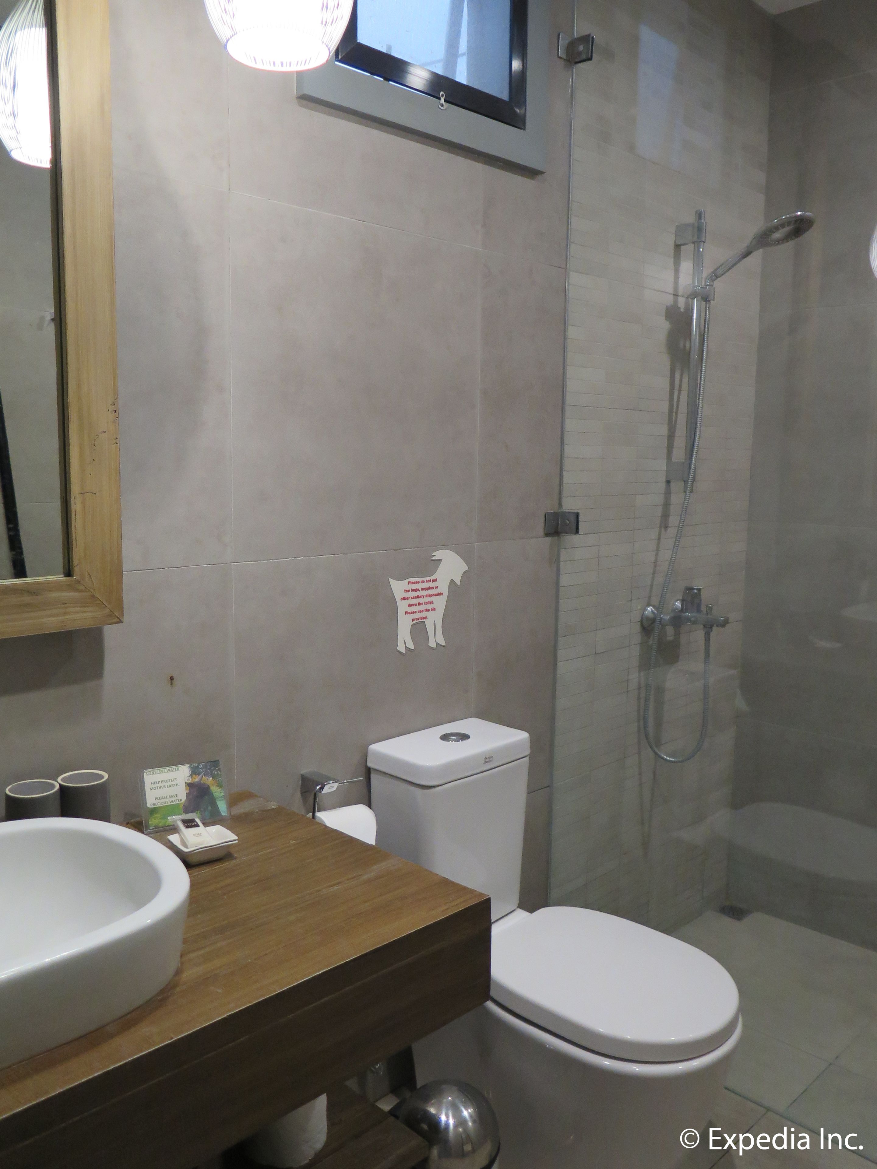 A bathroom with a toilet, sink, and shower.