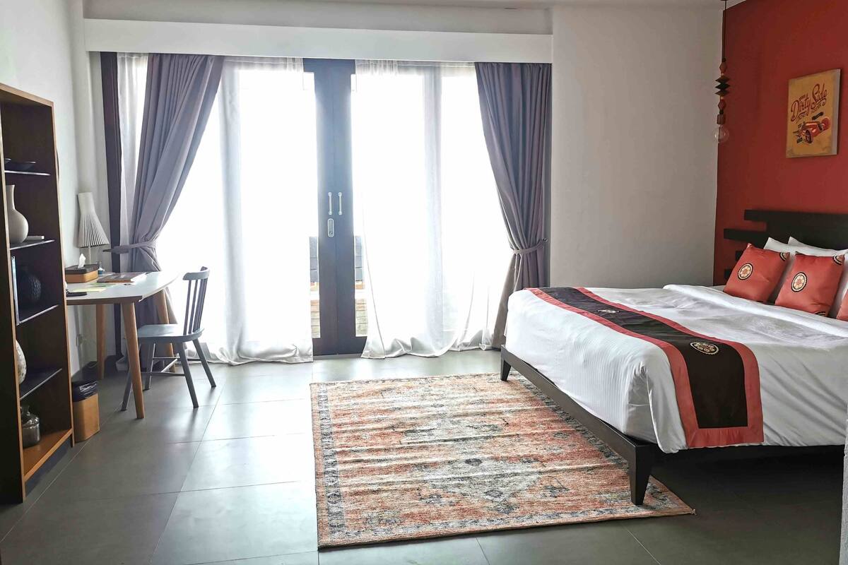 Une chambre d’hôtel avec un lit, un bureau et une chaise.