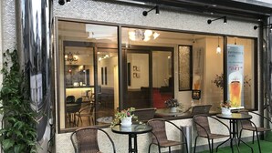 Un restaurant doté d’une terrasse, d’un mur en briques et d’une fa çade vitrée.