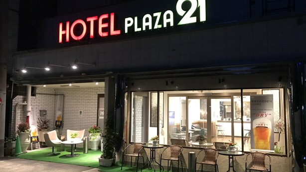 L'hôtel Plaza 21 se distingue par son architecture moderne, ses grandes fenêtres et son espace extérieur aménagé pour se détendre.