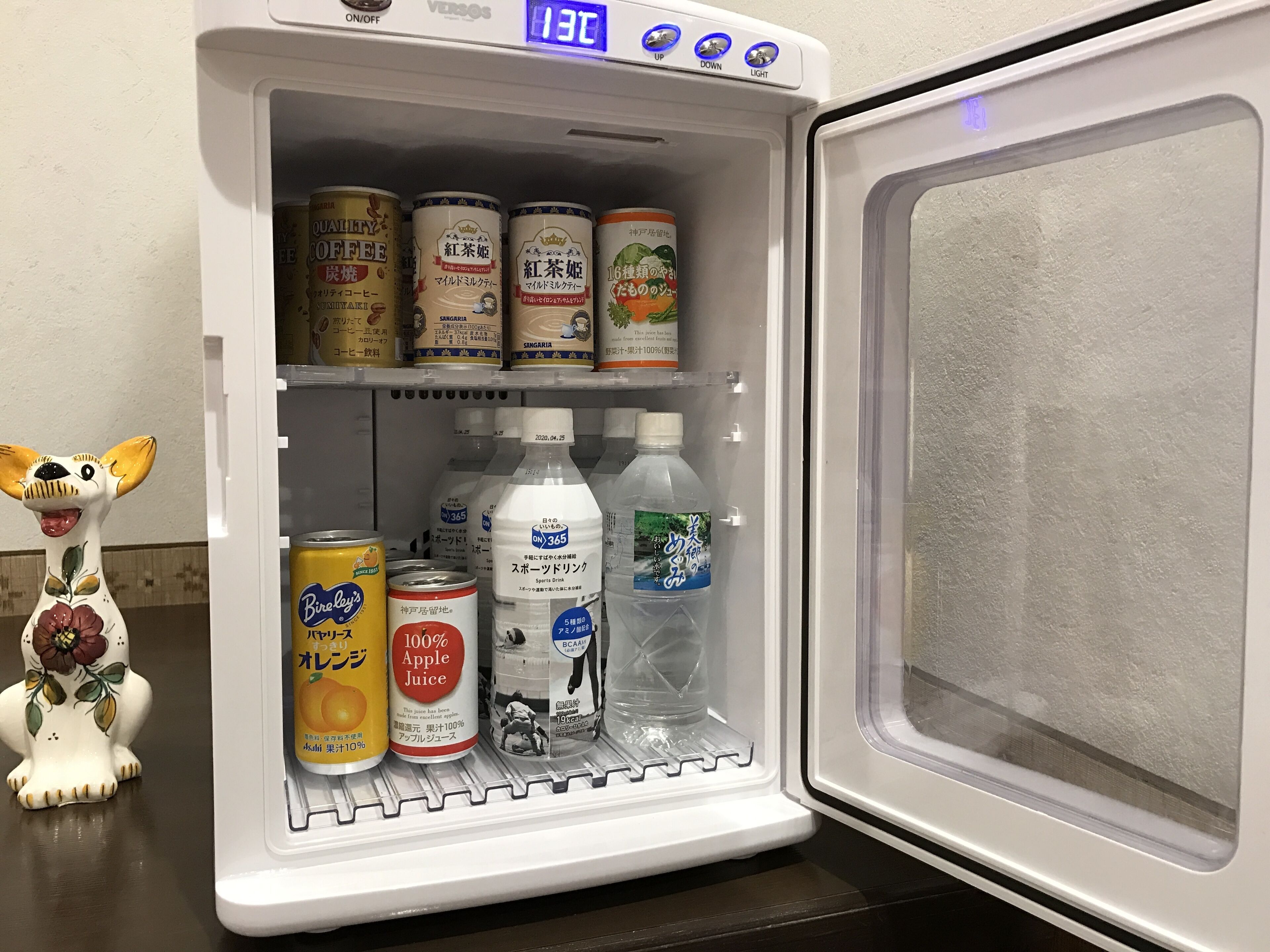 A refrigerator with multiple shelves containing various beverages and cans.