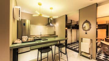 Cozinha moderna com ilha de vidro, eletrodomésticos de aço inoxidável e chão xadrez.