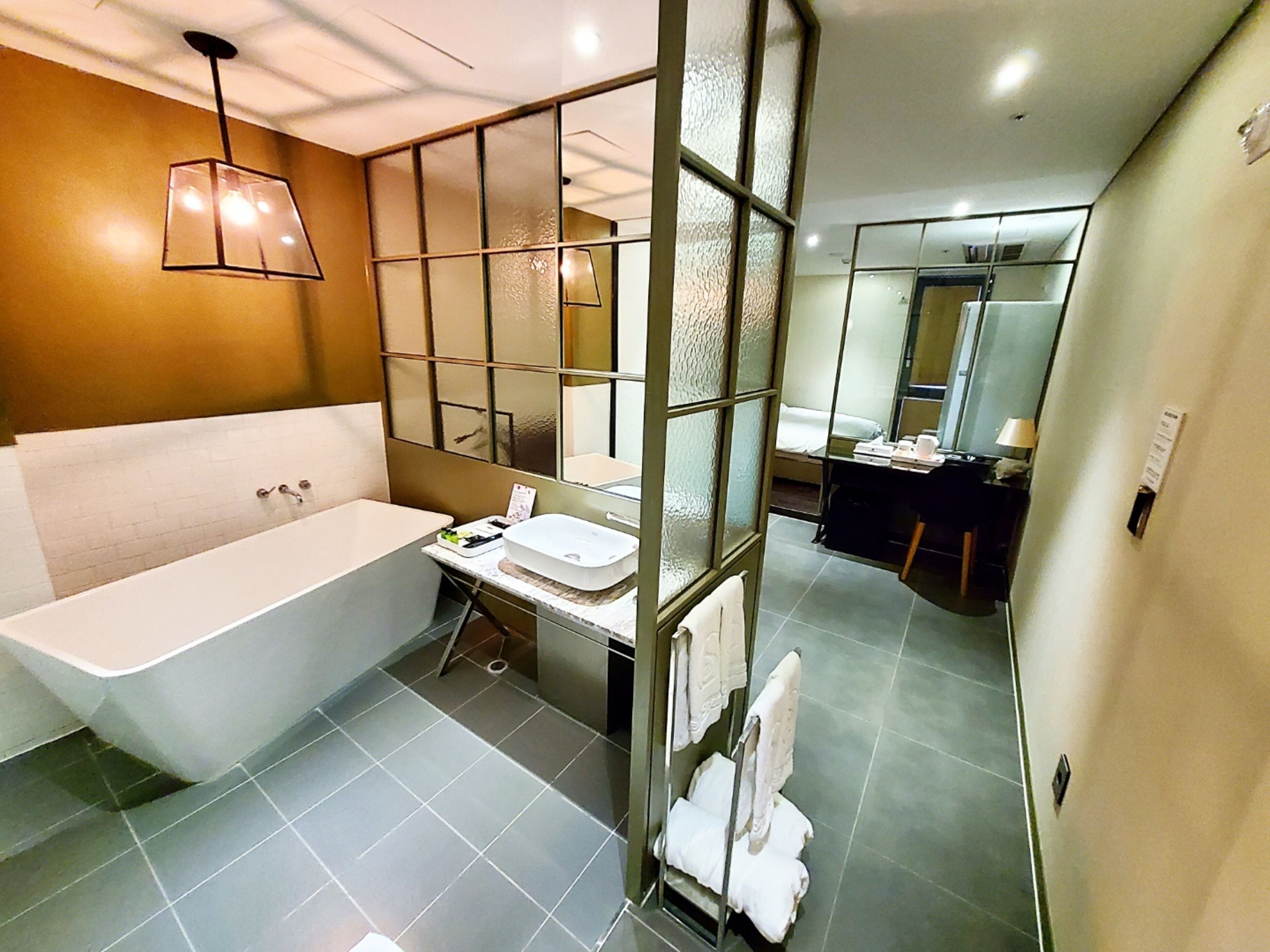 A modern bathroom with a freestanding bathtub, a vanity with a mirror, and a shower area.