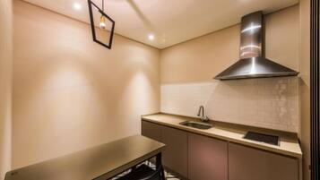 A compact kitchen with a built-in stove, a sink, and a small dining table.