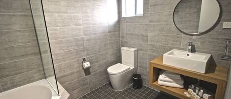 A modern bathroom with a bathtub, toilet, and sink.