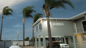 A residential building with a flat roof, a garage, and a white car parked in front. - Quays Hotel (Batemans Bay)