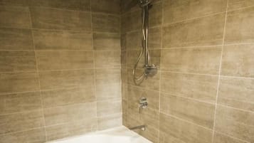 A modern bathroom with a freestanding bathtub, a showerhead, and a tiled floor.