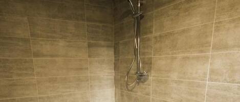 A modern bathroom with a freestanding bathtub, a showerhead, and a tiled floor.