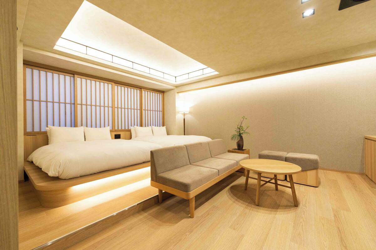 A modern bedroom with a bed, sofa, and round table.