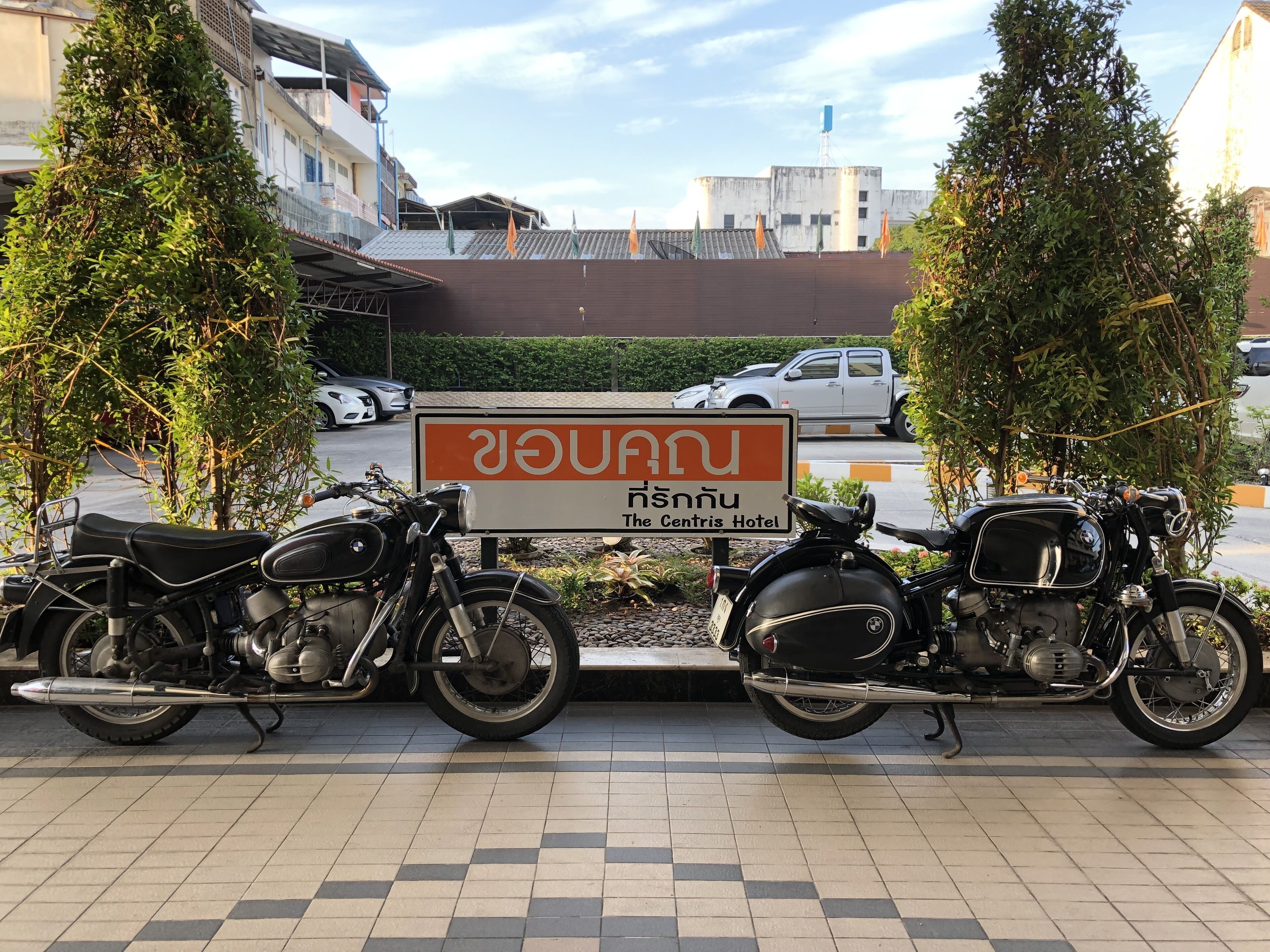 A sign for The Centris Hotel with two motorcycles parked in front.