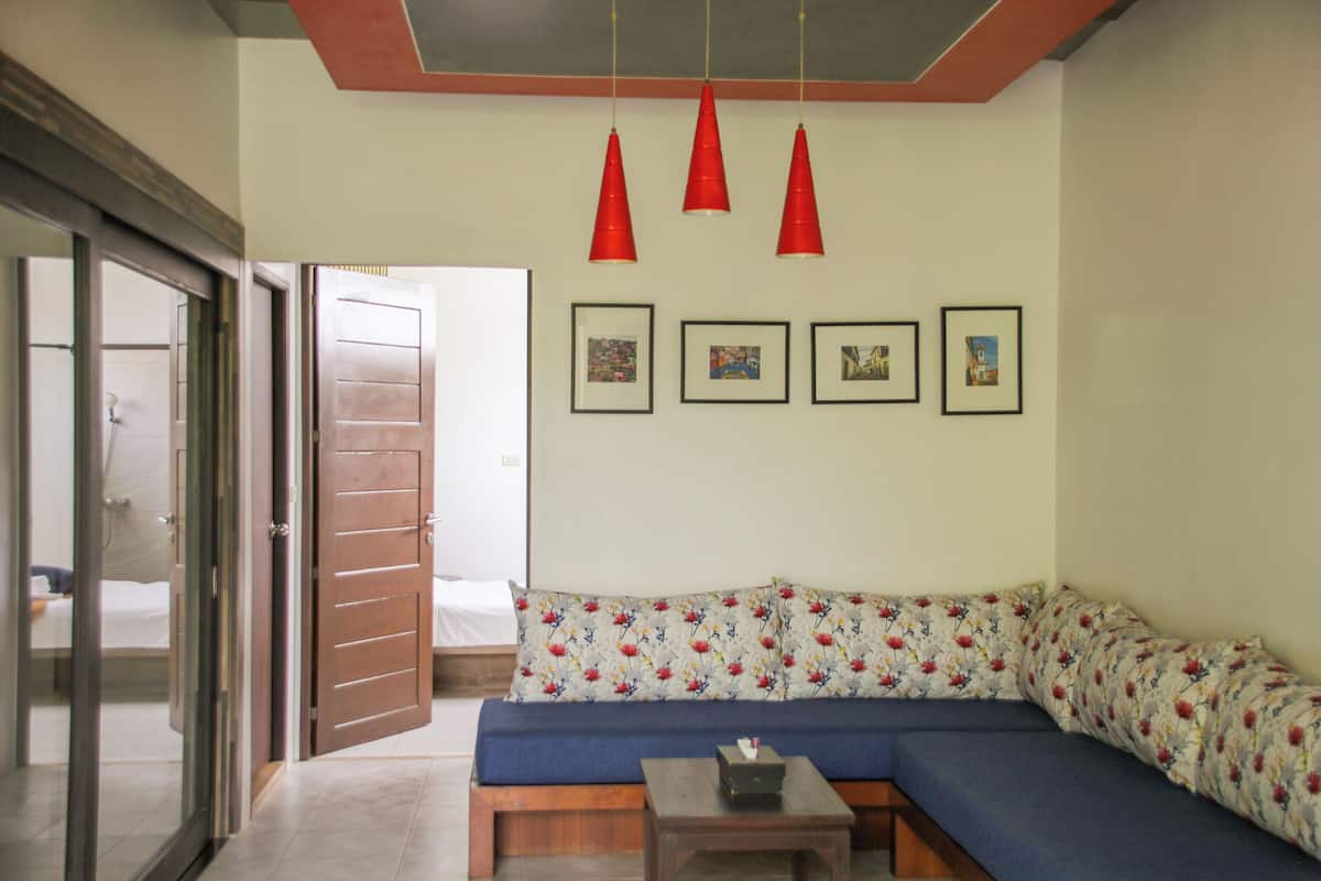 A living room with a sofa, a coffee table, and a sliding glass door leading to a balcony.