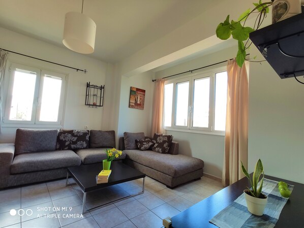 Deluxe Apartment, 1 Bedroom | Living room | 38-inch flat-screen TV with satellite channels, books - Kostas Apartments (Hersonissos)