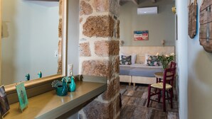 Casa de banho com parede de pedra, espelho e toucador de madeira.