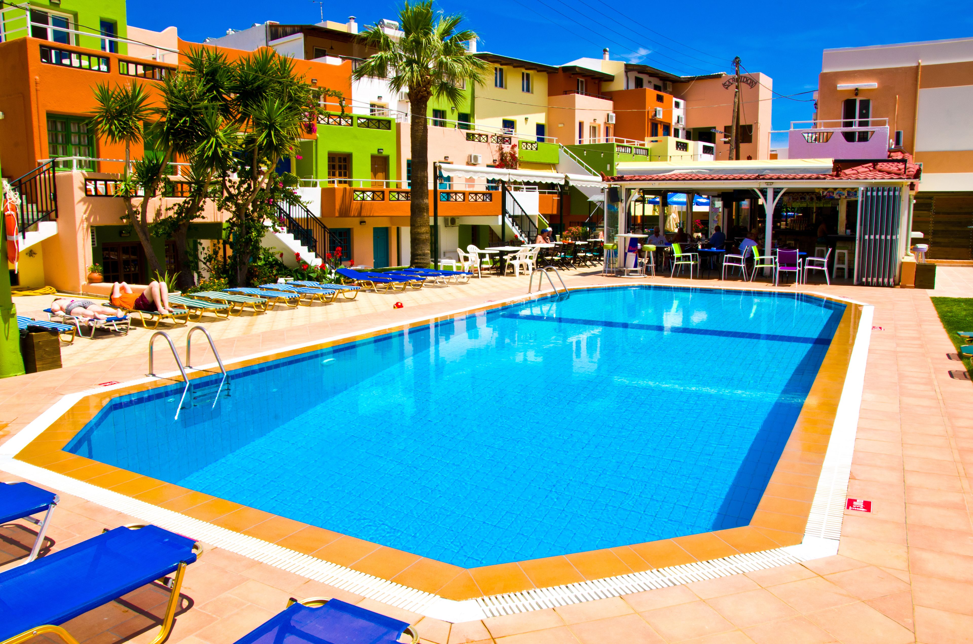 Una piscina con sillas de descanso y una zona de bar.