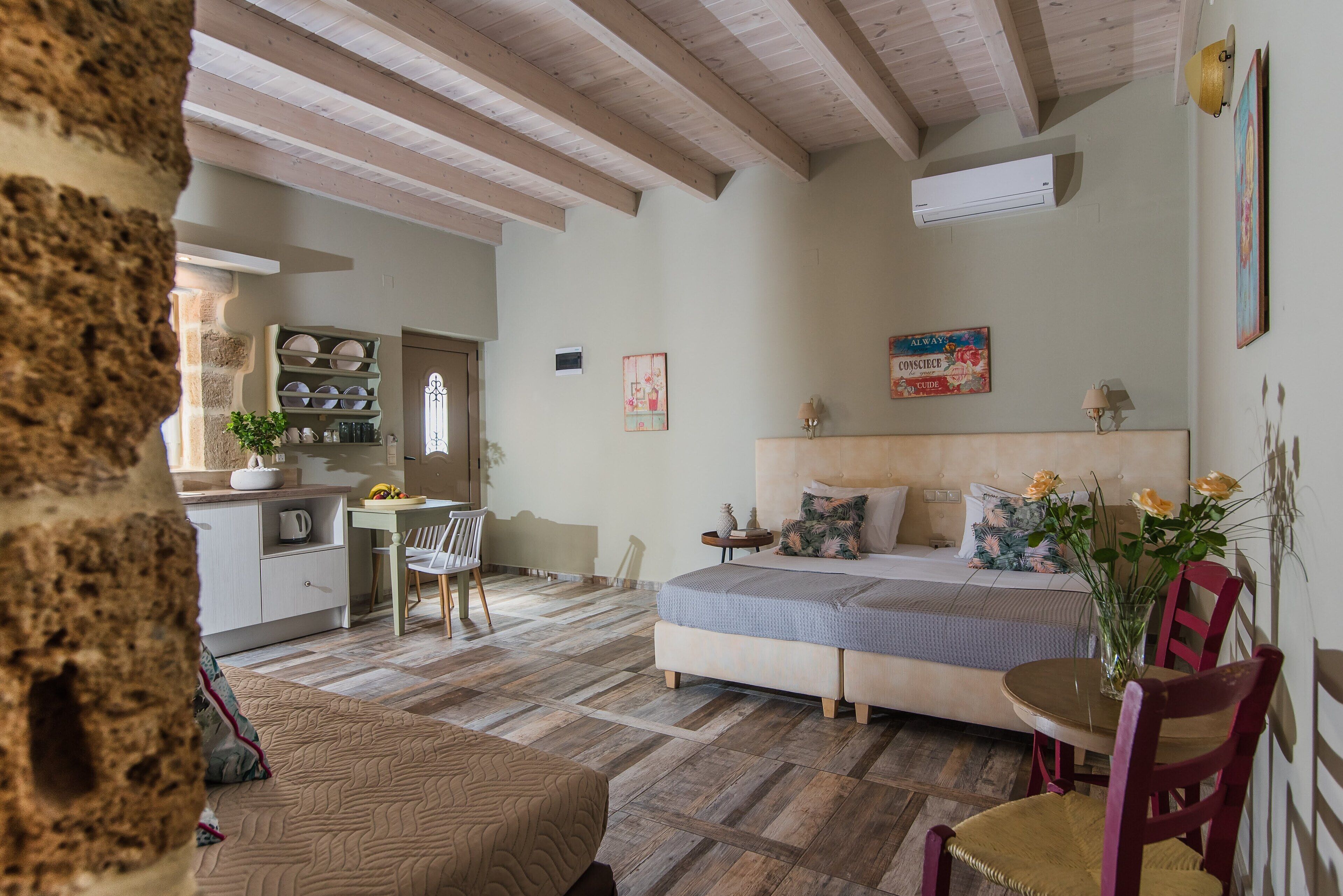 A cozy room with a bed, a dining table, and a kitchen area.