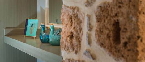 A wooden shelf with a teal decorative piece and a blue ceramic duck.